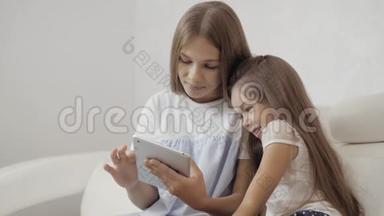 两个姐姐看着平板电脑，坐在沙发上玩游戏，小婴儿和成年妹妹